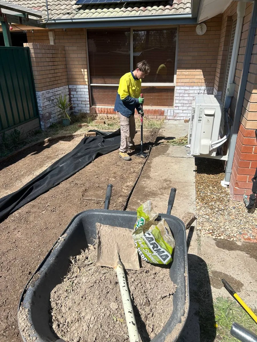 Anthony compacting soil in a garden
